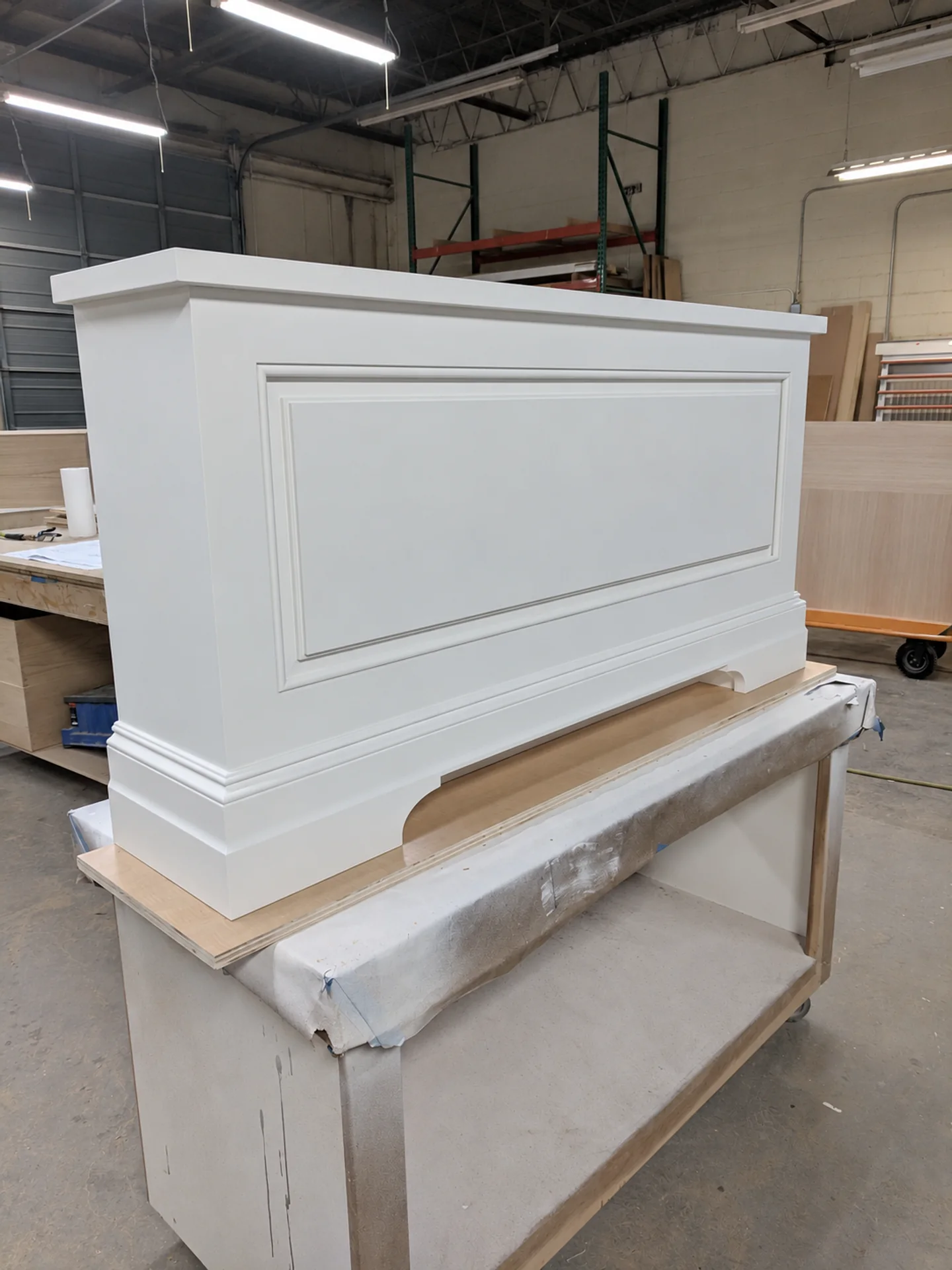 Painted architectural panel with inset moulding, a fitted corner and base trim on a JQ workshop bench