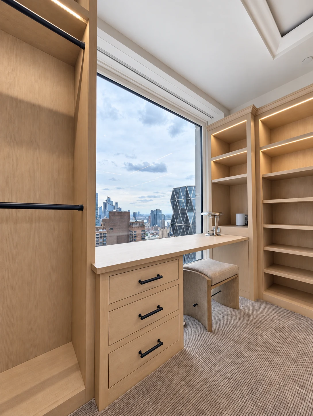Oak countertop and drawer cabinetry fitted beneath the window in the Central Park South dressing room