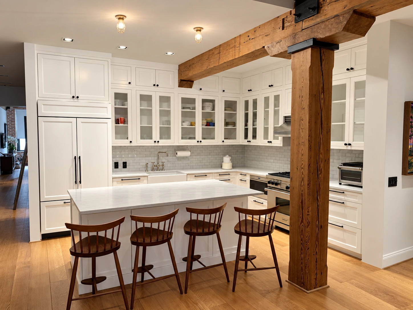 Painted kitchen cabinetry and an island beneath exposed timber beams in a Lower Manhattan loft