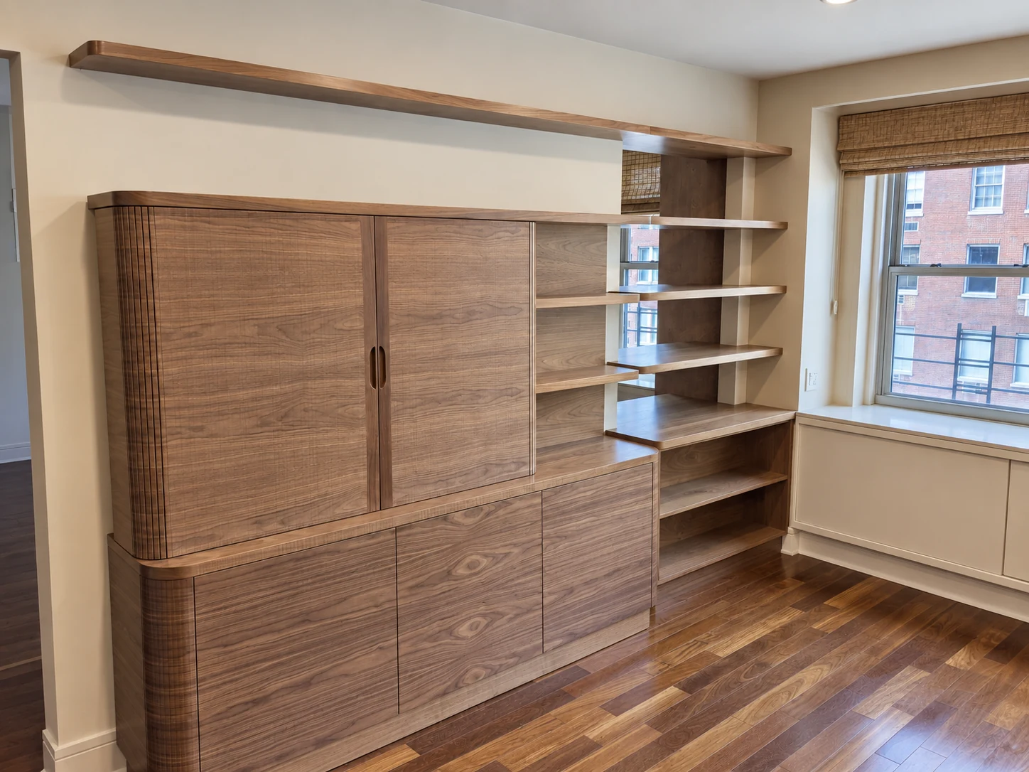 Lenox Hill walnut cabinetry with rounded returns, tambour door panels and continuous open shelving