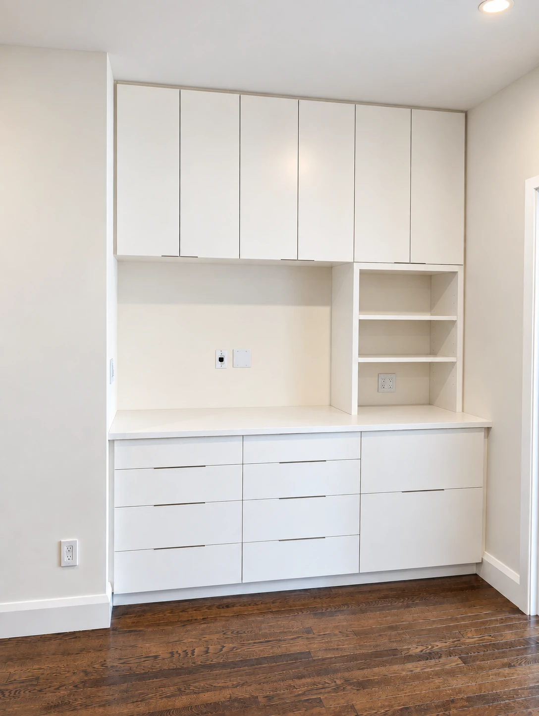 Painted media and storage cabinetry with a central recess in Chelsea
